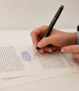 Traductora jurada català-francès signant un document oficial